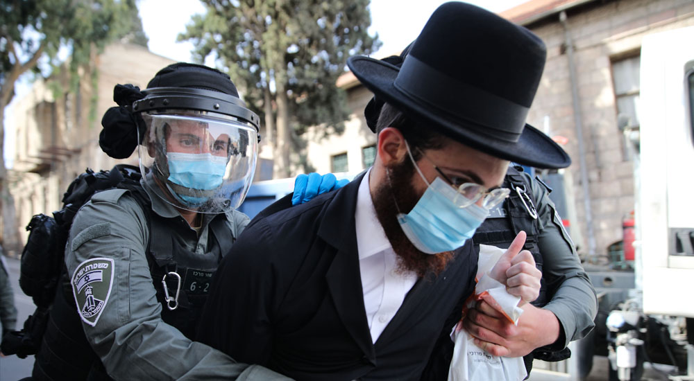 İsrail’in Batı Kudüs’te salgının yayılımını azaltmak amaçlı getirdiği kısıtlamaları protesto eden bir ultra-Ortodoks Yahudi gözaltına alınıyor.